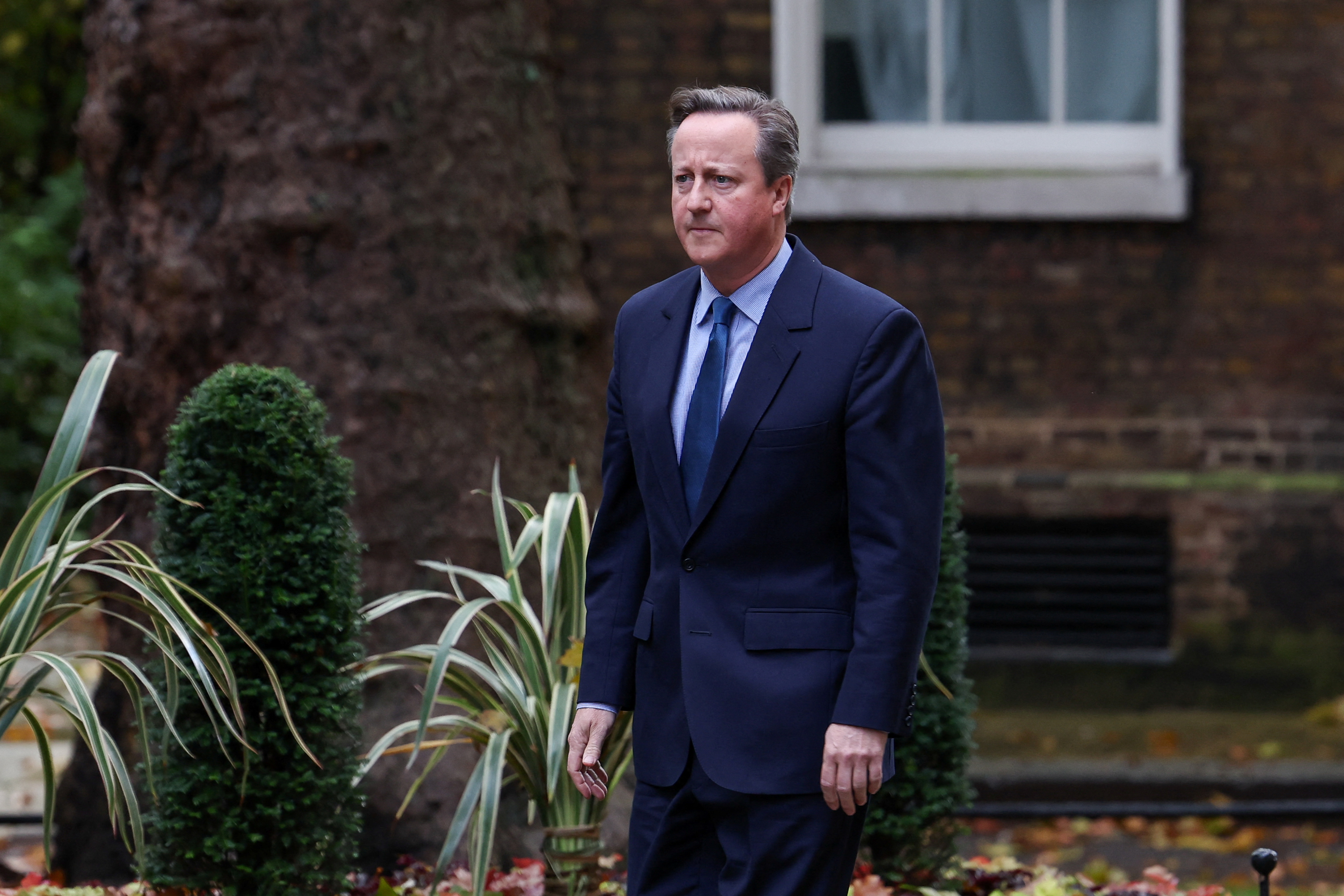 Former British Prime Minister David Cameron walks outside 10 Downing Street in London