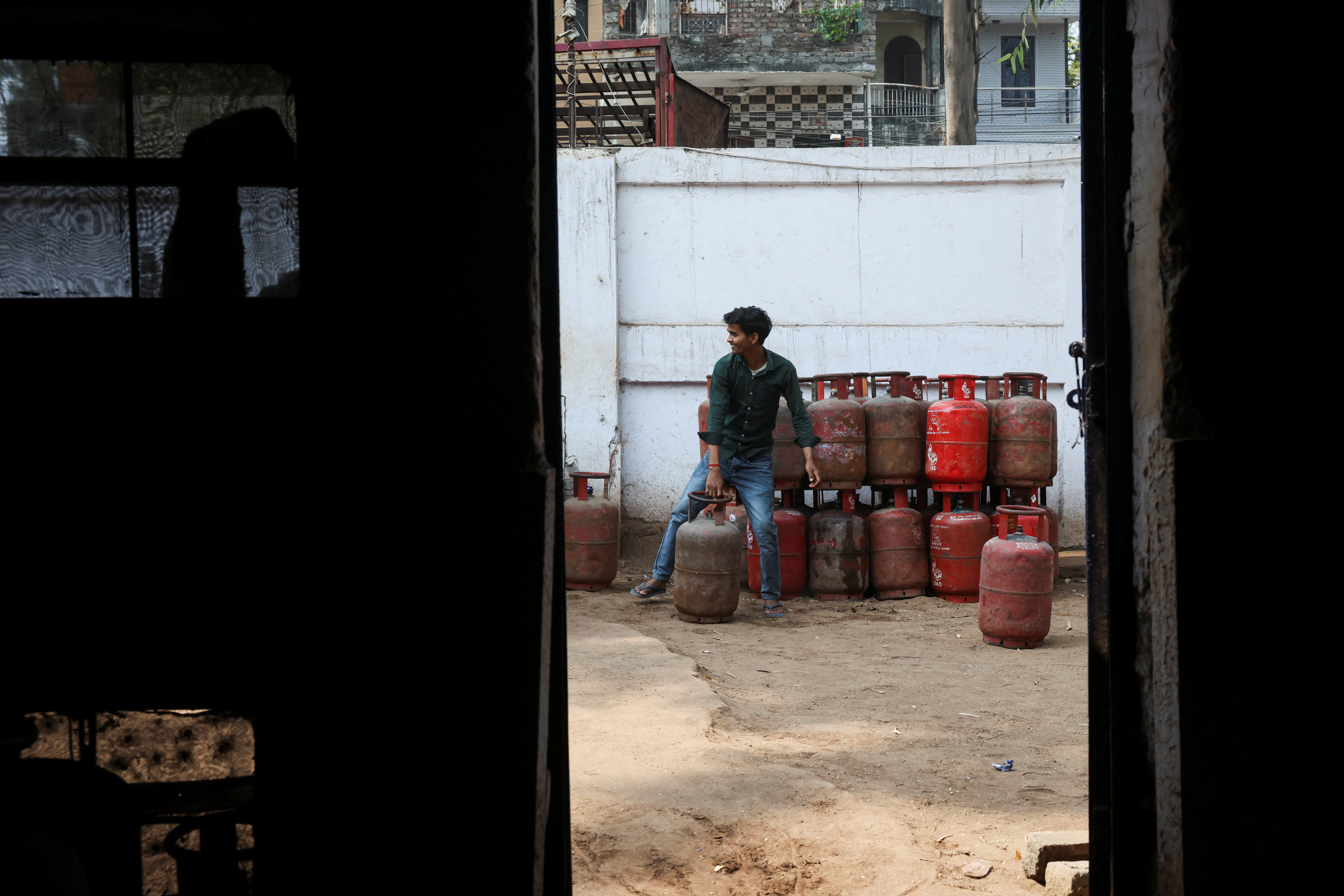 A worker moves an LPG cylinder at a godown