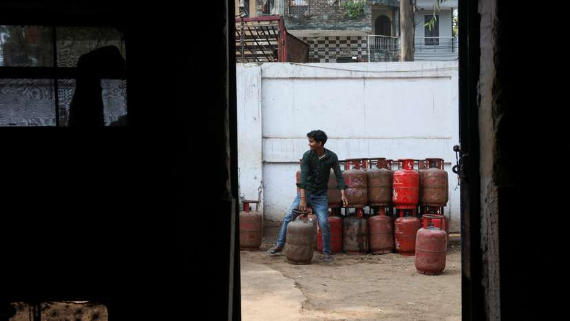 A worker moves an LPG cylinder at a godown