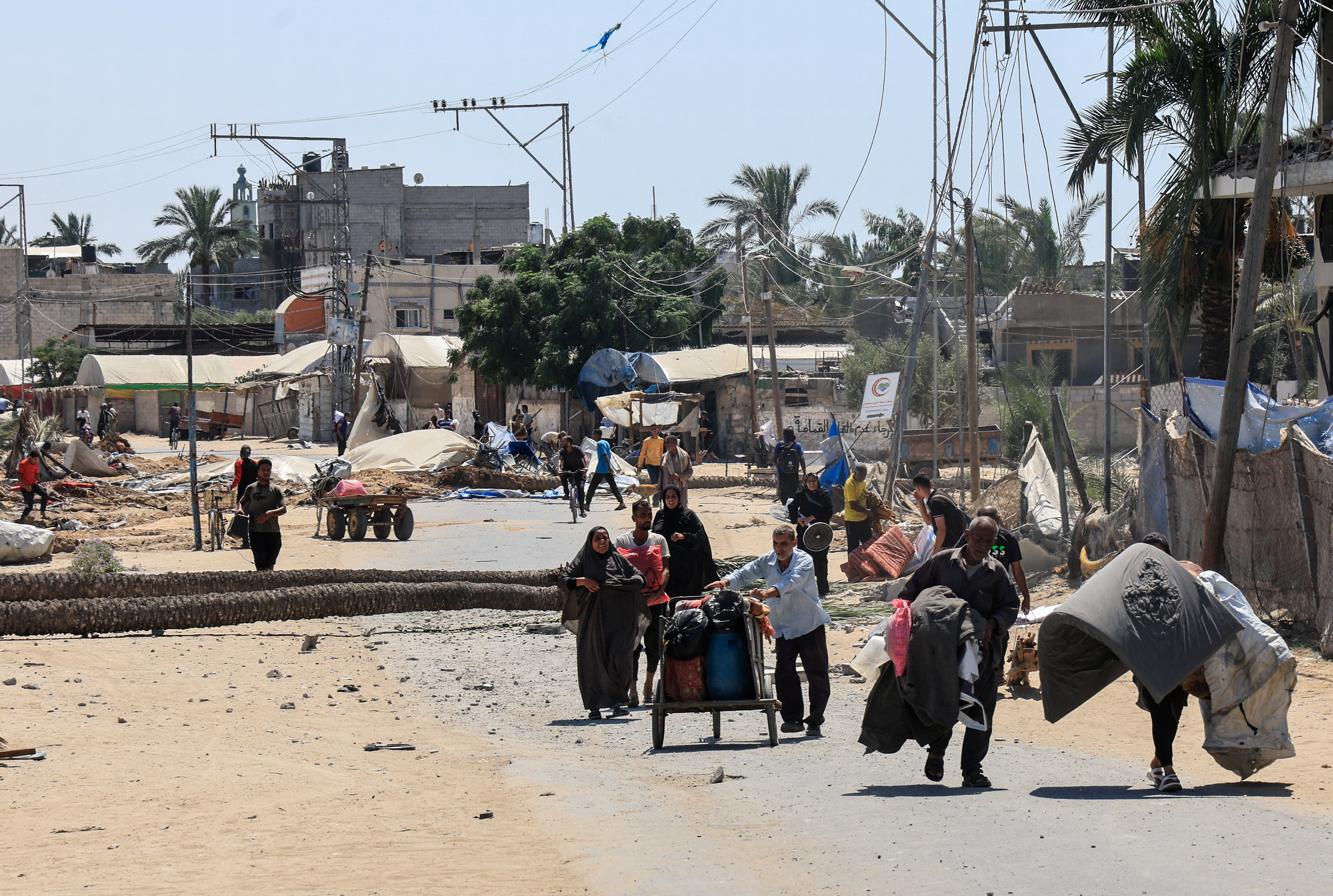 Displaced Palestinians inspect shelters damaged during an Israeli military operation in Deir Al-Balah