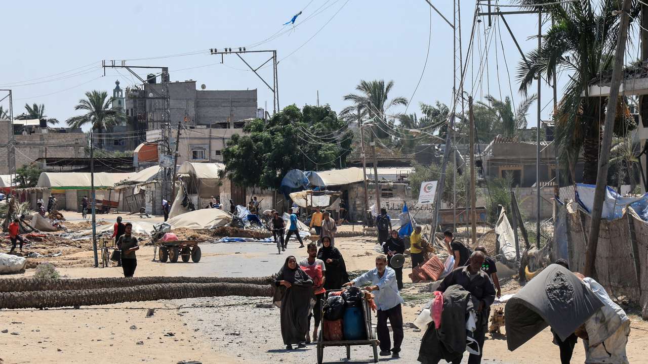 Displaced Palestinians inspect shelters damaged during an Israeli military operation in Deir Al-Balah