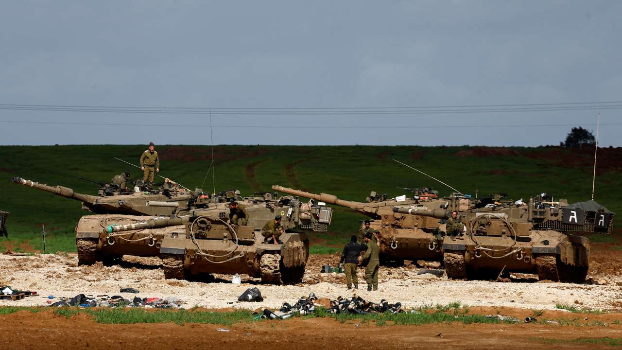 Israeli soldiers work by their tanks near Israel-Gaza border