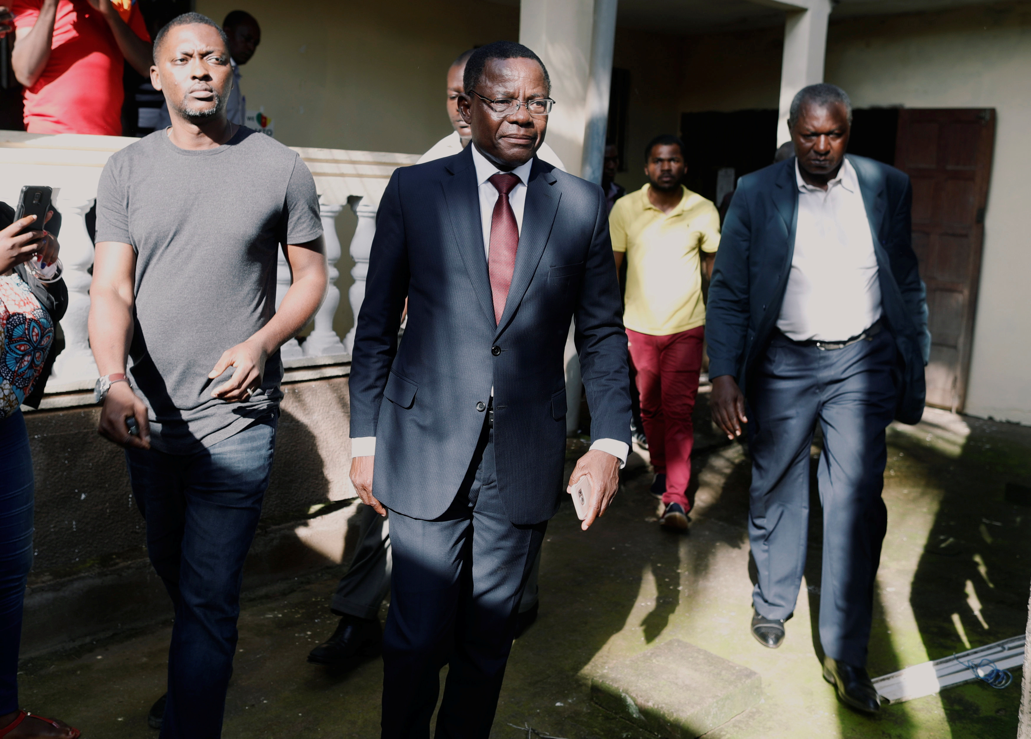Maurice Kamto, a presidential candidate of Renaissance Movement (MRC), walks with his staff after his news conference at his headquarter in Yaounde