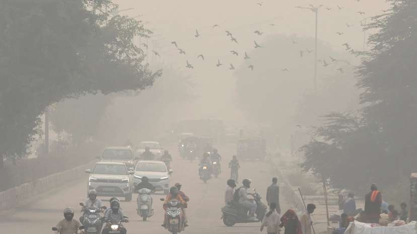FILE PHOTO: People and vehicles are seen on a road amidst the morning smog in New Delhi
