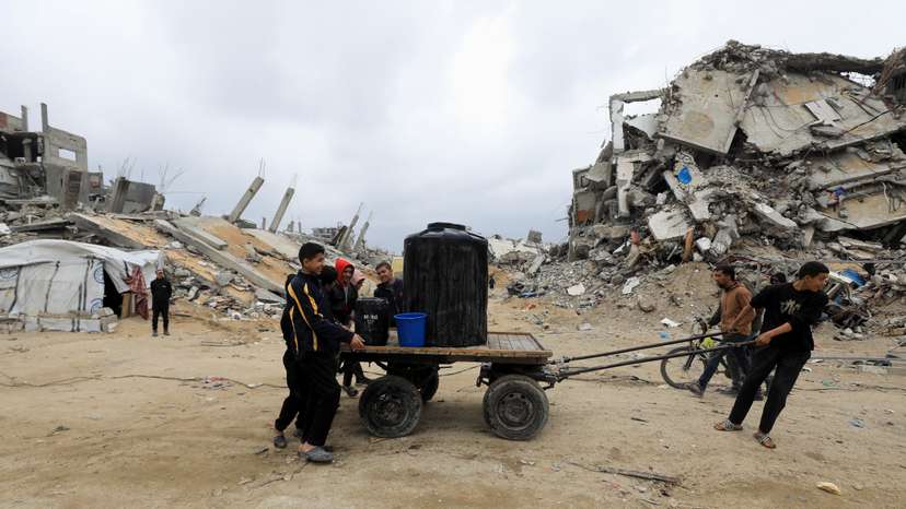 Palestinians push a cart with water tank in Jabalia refugee camp