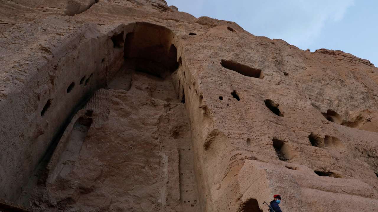 FILE PHOTO: A Taliban soldier stands guard in front of the ruins of a 1500-year-old Buddha statue in Bamyan