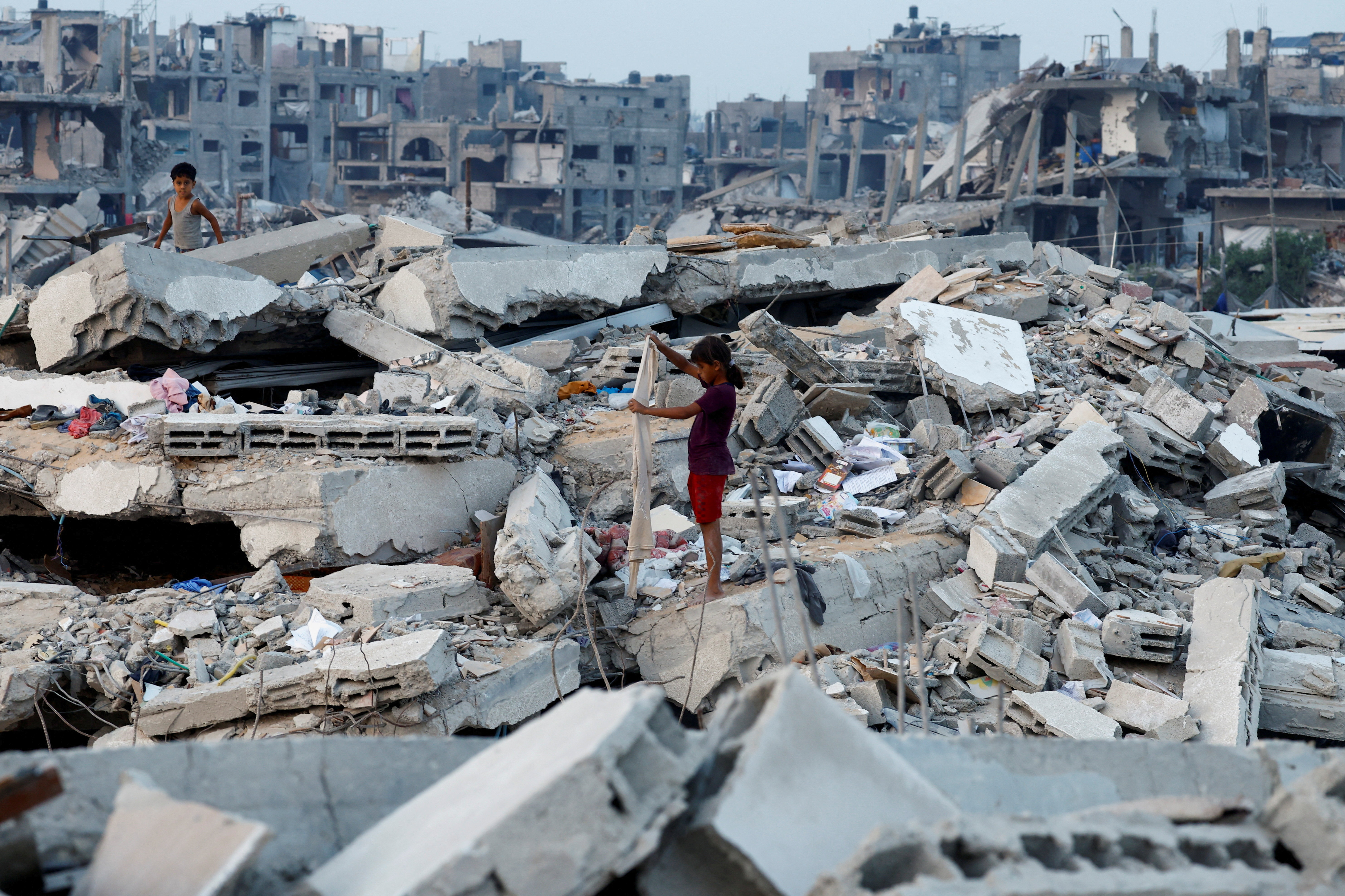 Palestinian children stand on the rubble of destroyed buildings, amid a ceasefire between Israel and Hamas, in Jabalia