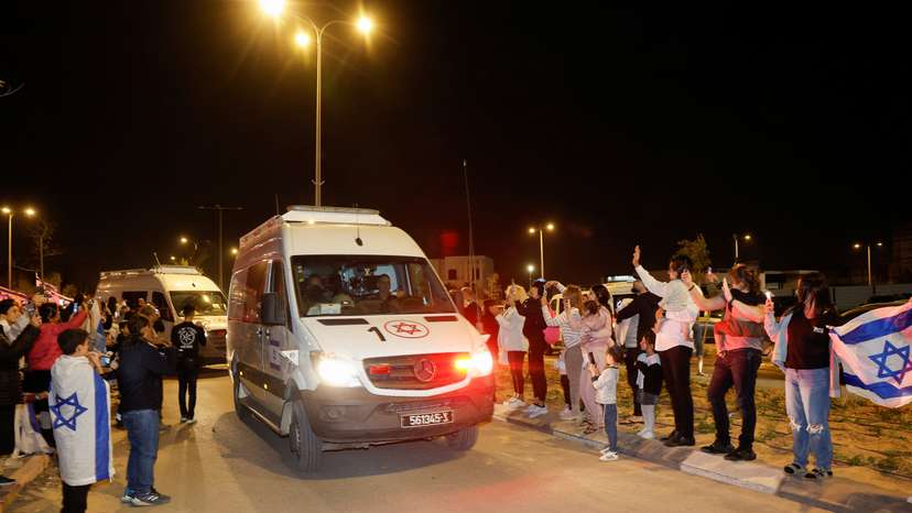 People react to the convoy carrying newly released hostages, in Ofakim