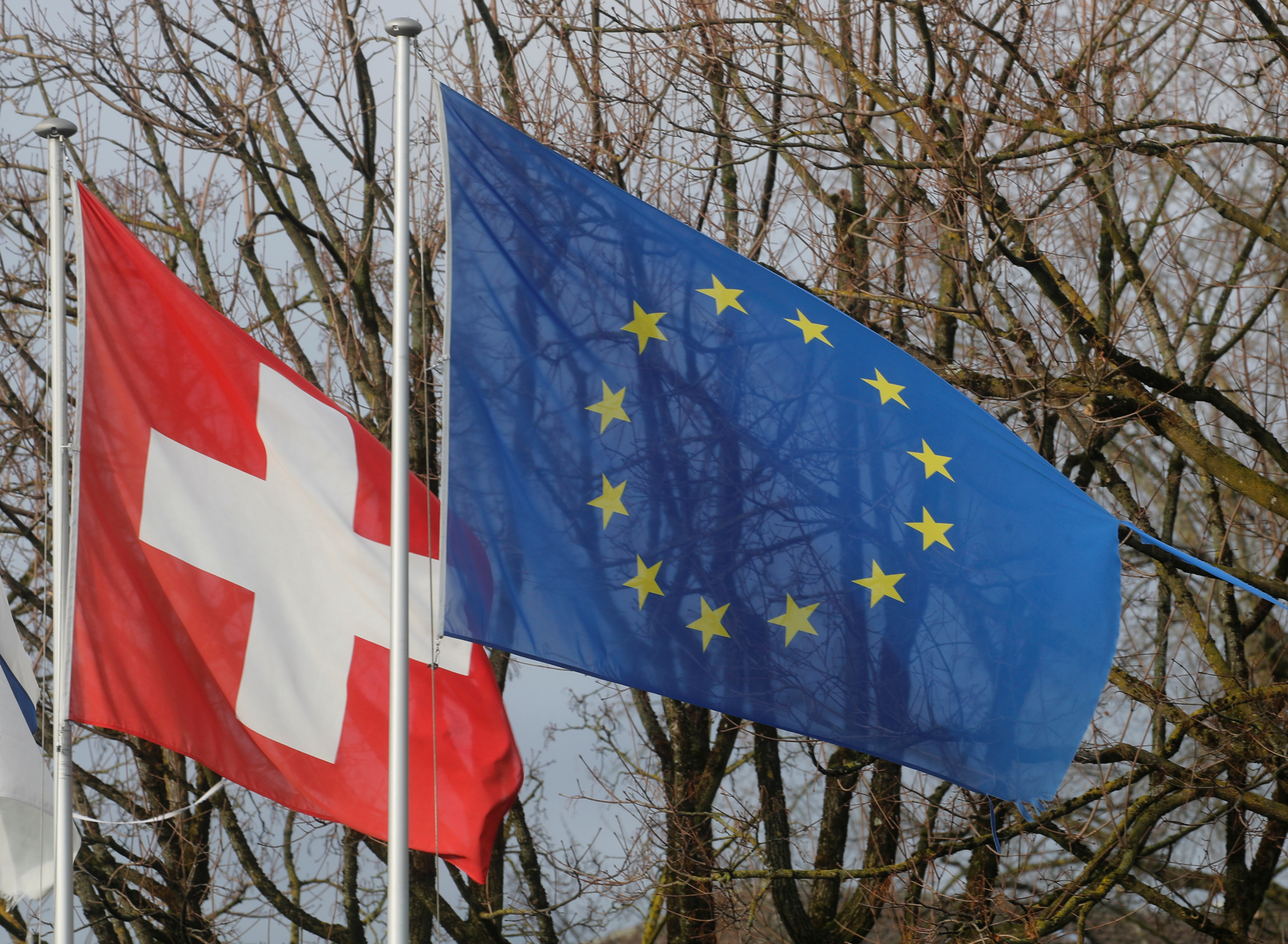 Switzerland's national flag flies beside the one of the European Union in Steinhausen