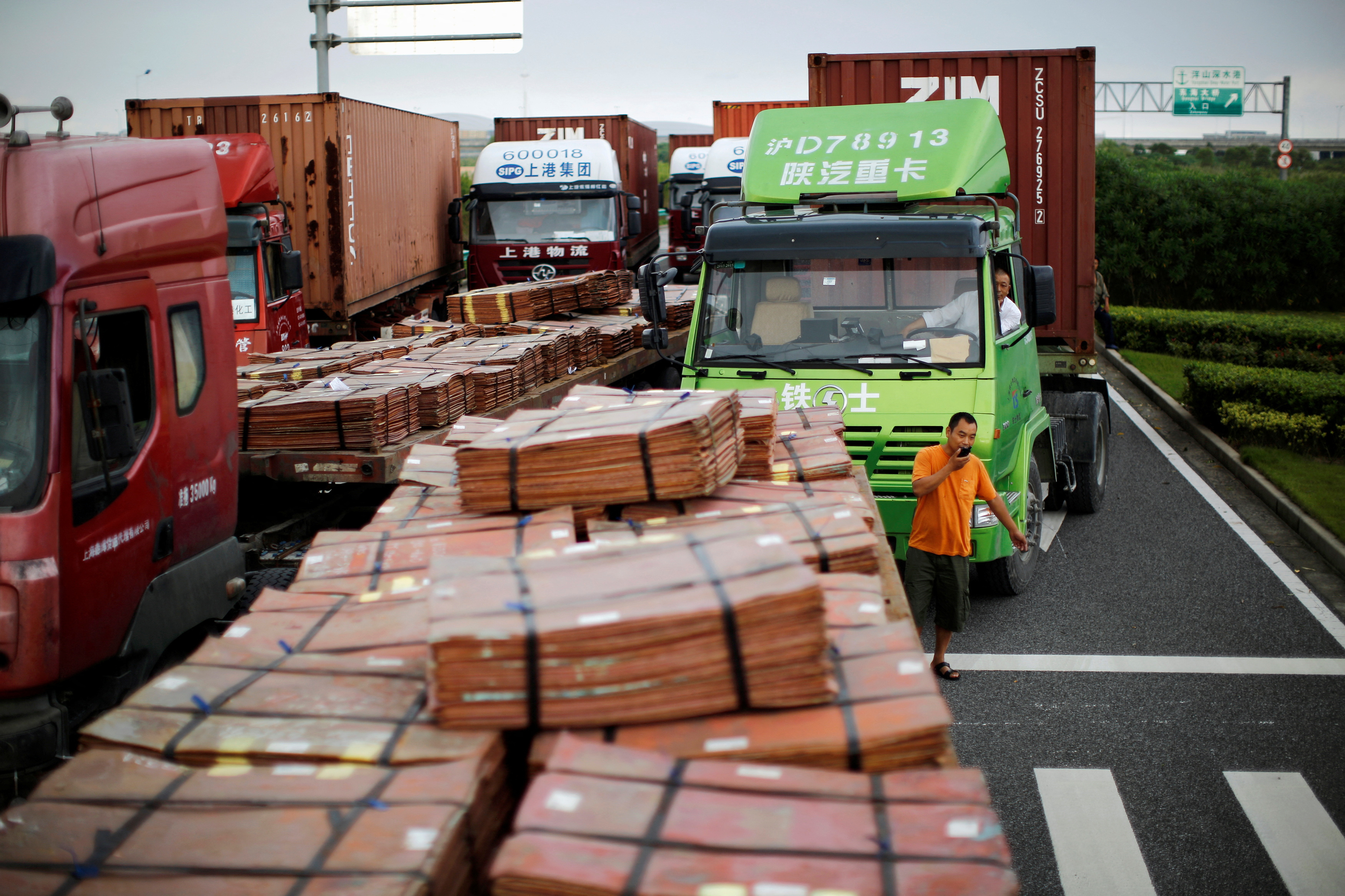 FILE PHOTO: Trucks carrying copper and other goods are seen waiting to enter an area of the Shanghai Free Trade Zone, in Shanghai