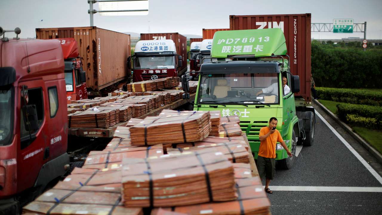FILE PHOTO: Trucks carrying copper and other goods are seen waiting to enter an area of the Shanghai Free Trade Zone, in Shanghai