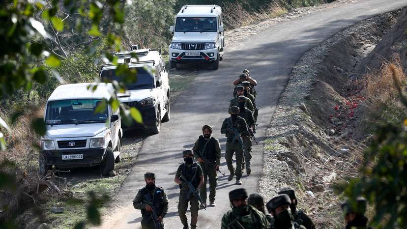 Indian security force personnel patrol near the site of a gun battle with suspected militants in a forest area in Kathua district