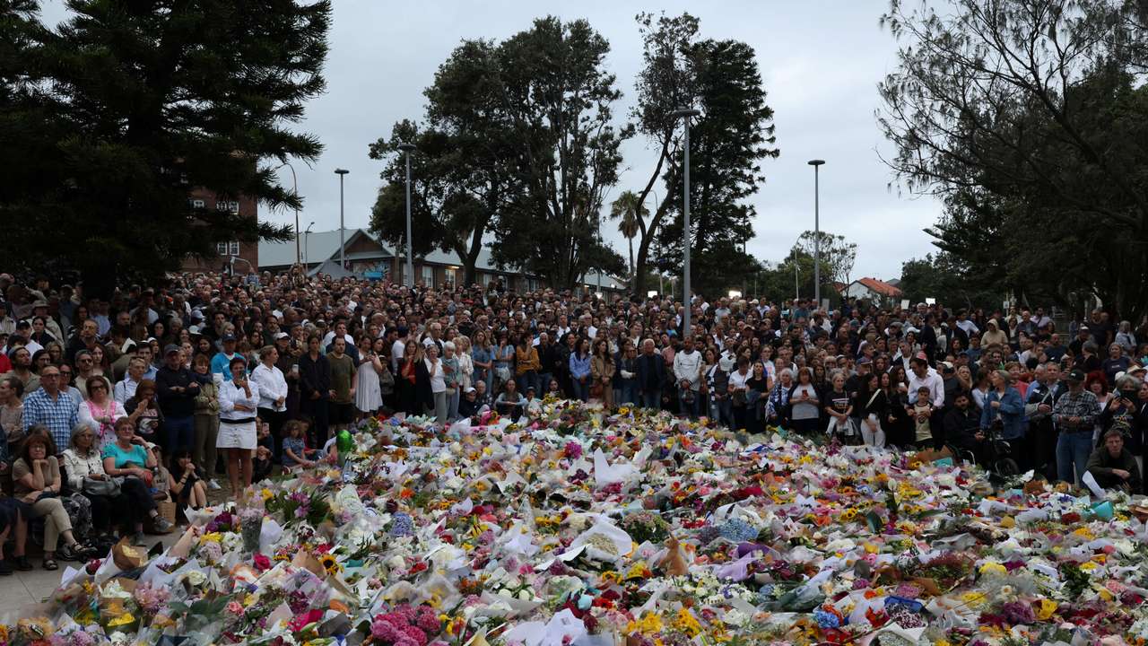 People lay flowers and pay tribute at Bondi Beach to honour the victims of a mass shooting that targeted a Jewish Holiday celebration on Sunday at Bondi Beach, in Sydney