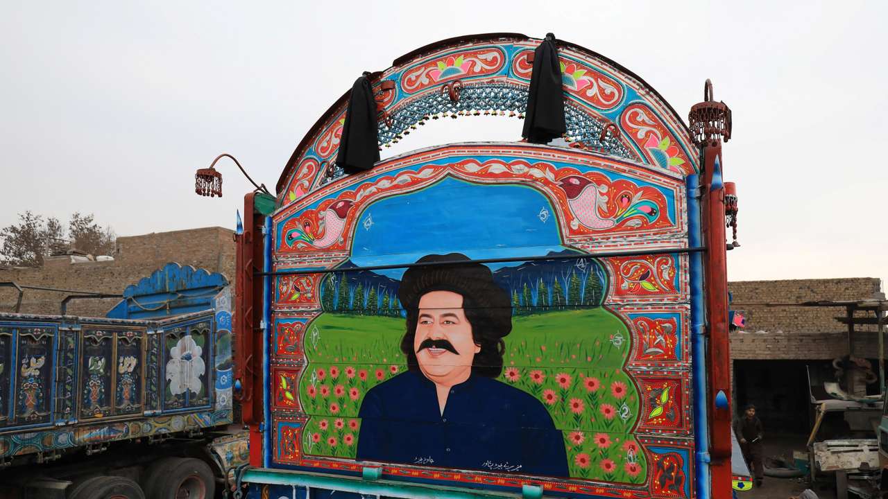 A decorated supply truck with a portrait of Ali Wazir, a politician from South Waziristan, is seen parked in a workshop in Peshawar