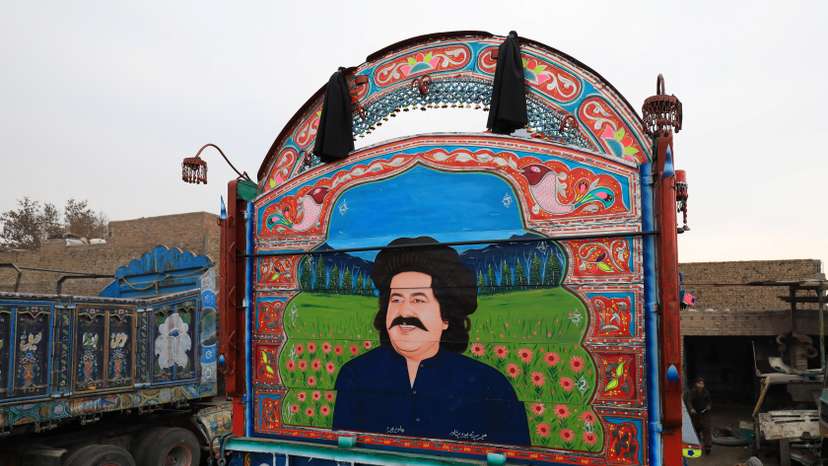 A decorated supply truck with a portrait of Ali Wazir, a politician from South Waziristan, is seen parked in a workshop in Peshawar