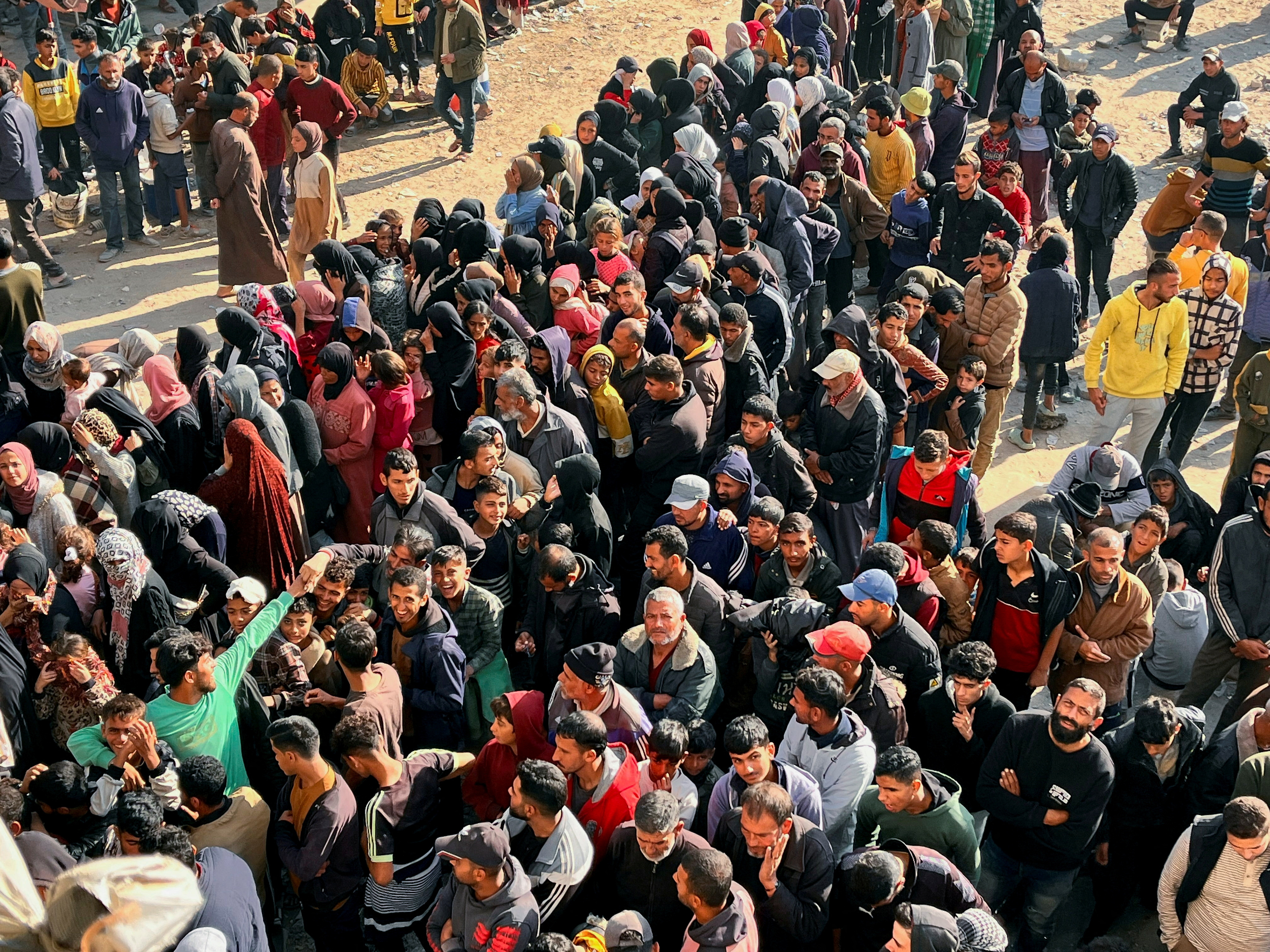 Palestinians gather to buy bread from a bakery, in Khan Younis