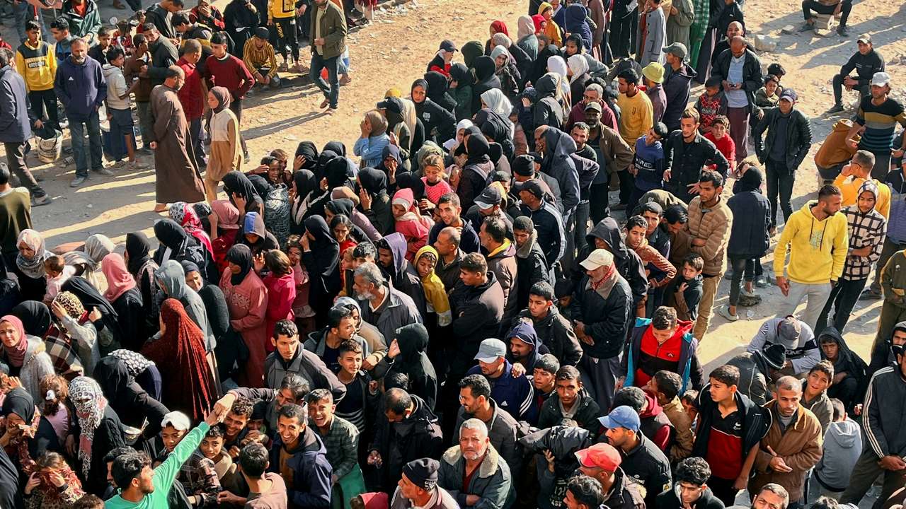 Palestinians gather to buy bread from a bakery, in Khan Younis