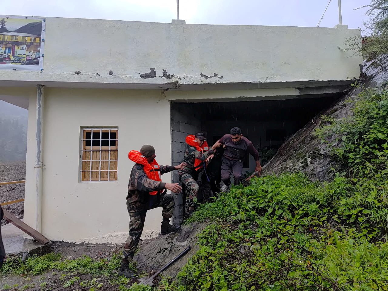Rescuers help people amid flash floods in a location given as Dharali