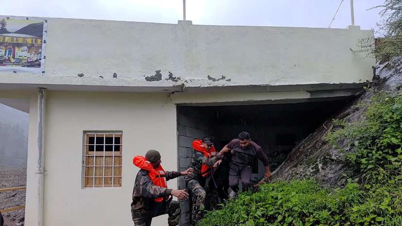 Rescuers help people amid flash floods in a location given as Dharali