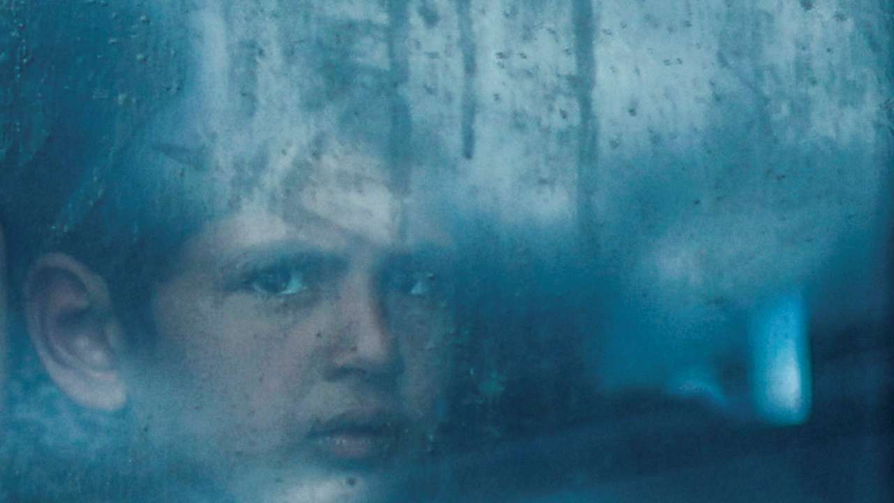 A displaced Palestinian looks out from a bus window, in Rafah