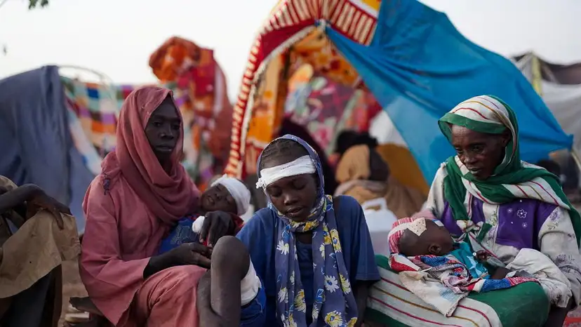 The grandmother of Ikram Abdelhameed looks on next her family while sitting at a camp for displaced people who fled from al-Fashir to Tawila