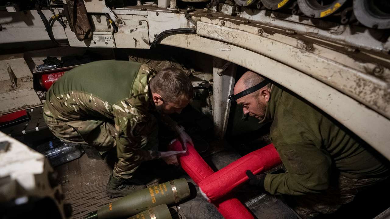 Ukrainian servicemen load shells in an M109 self-propelled howitzer before firing towards Russian troops near the town of Vovchansk