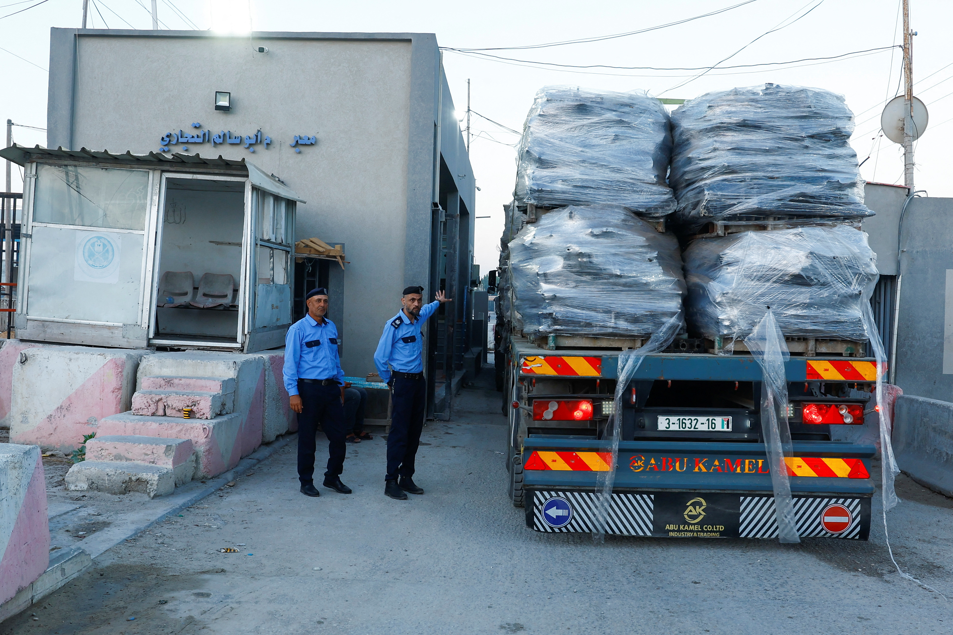 Palestinian police officers walk at the commercial crossing of Kerem Shalom, as Israel ends a ban on exports from Gaza, in Rafah