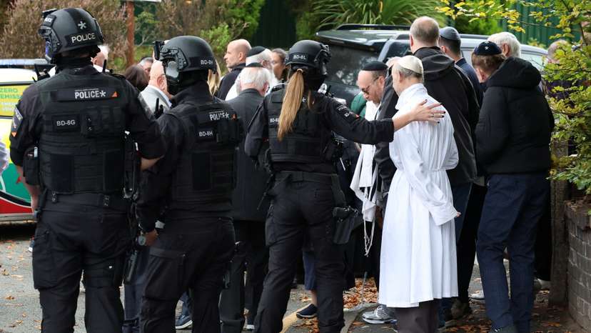 People gather near the scene following an incident outside a synagogue, in Manchester