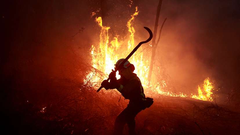 A firefighter from Galicia tackles a forest blaze near the Asturian village of Piedrafita