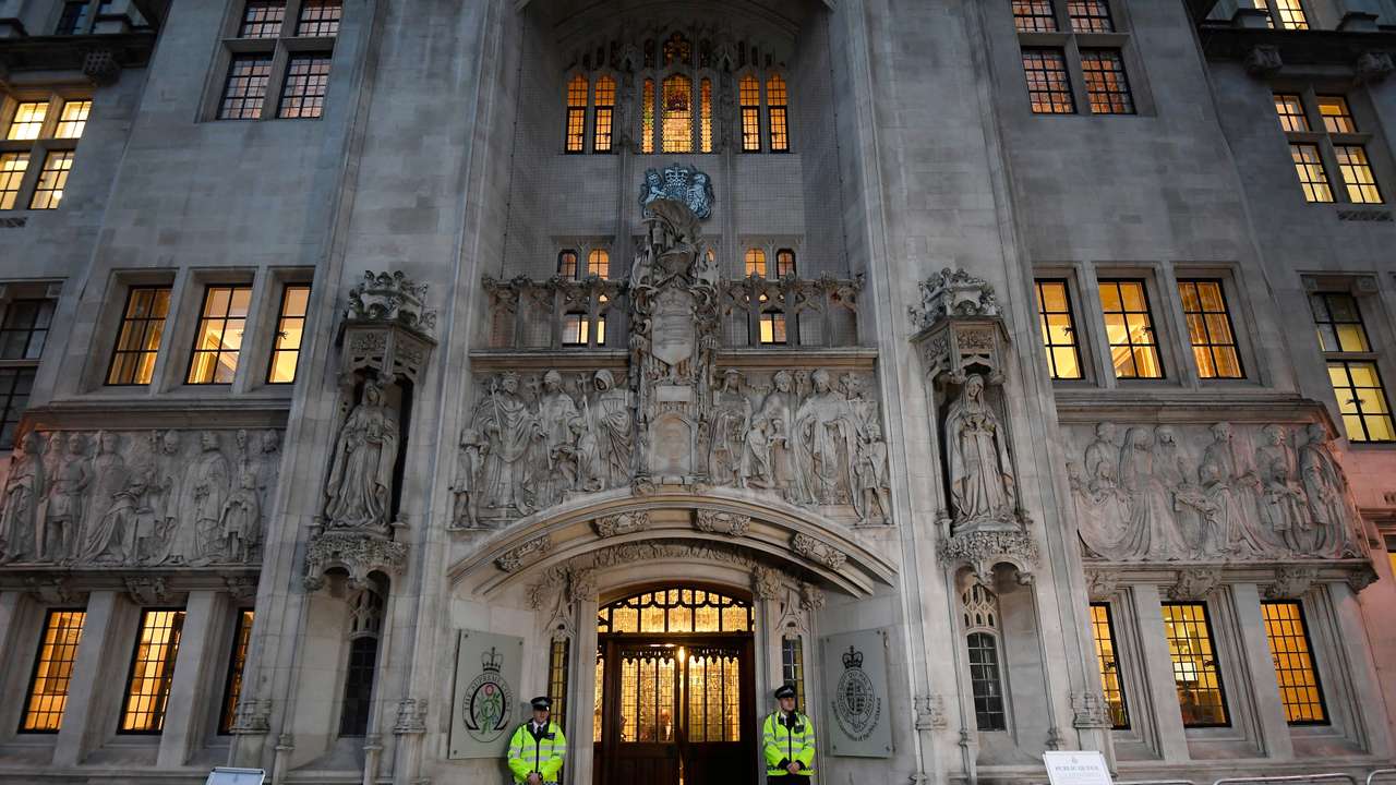 FILE PHOTO: Police officers stand on duty outside the Supreme Court in Parliament Square, central London