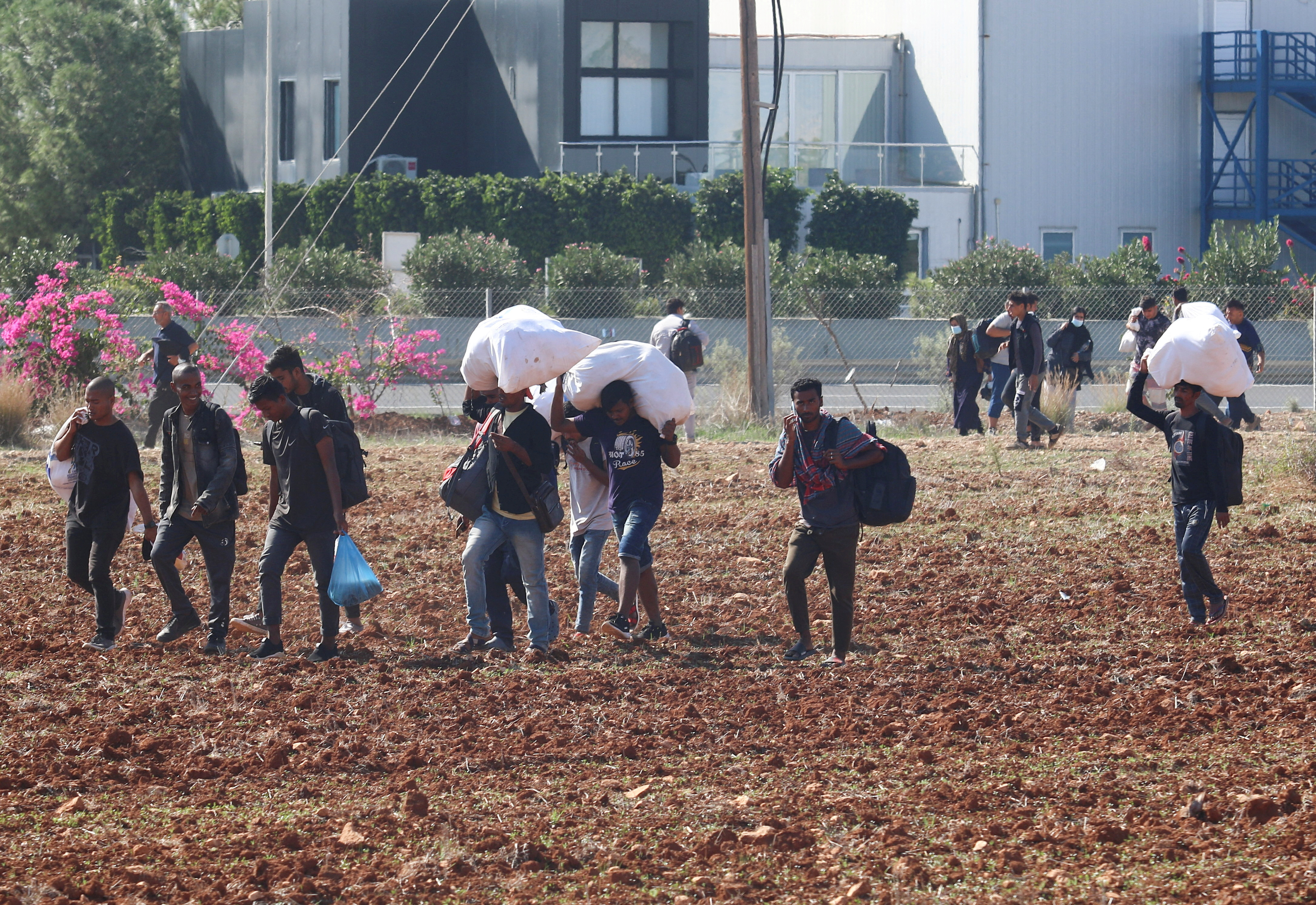 FILE PHOTO: Migrants leave Pournara refugee camp during clashes on the outskirts of Nicosia