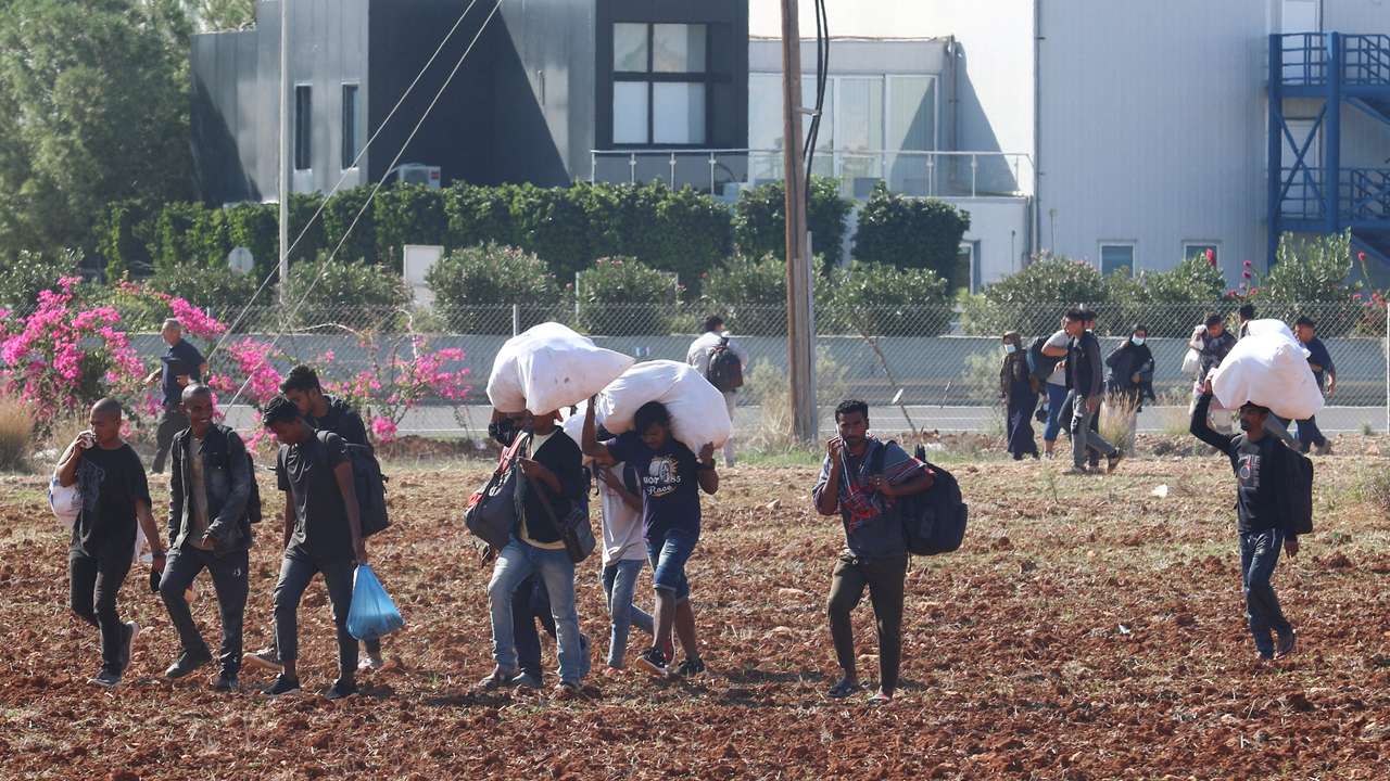 FILE PHOTO: Migrants leave Pournara refugee camp during clashes on the outskirts of Nicosia
