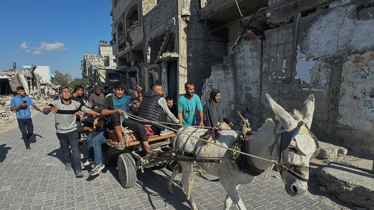 Palestinians assist casualties following an Israeli strike, in Beit Lahiya