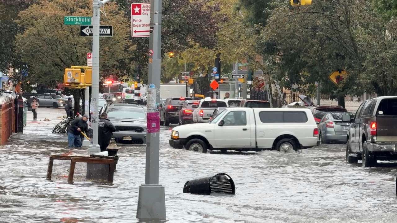 Vehicles move through floodwater in New York