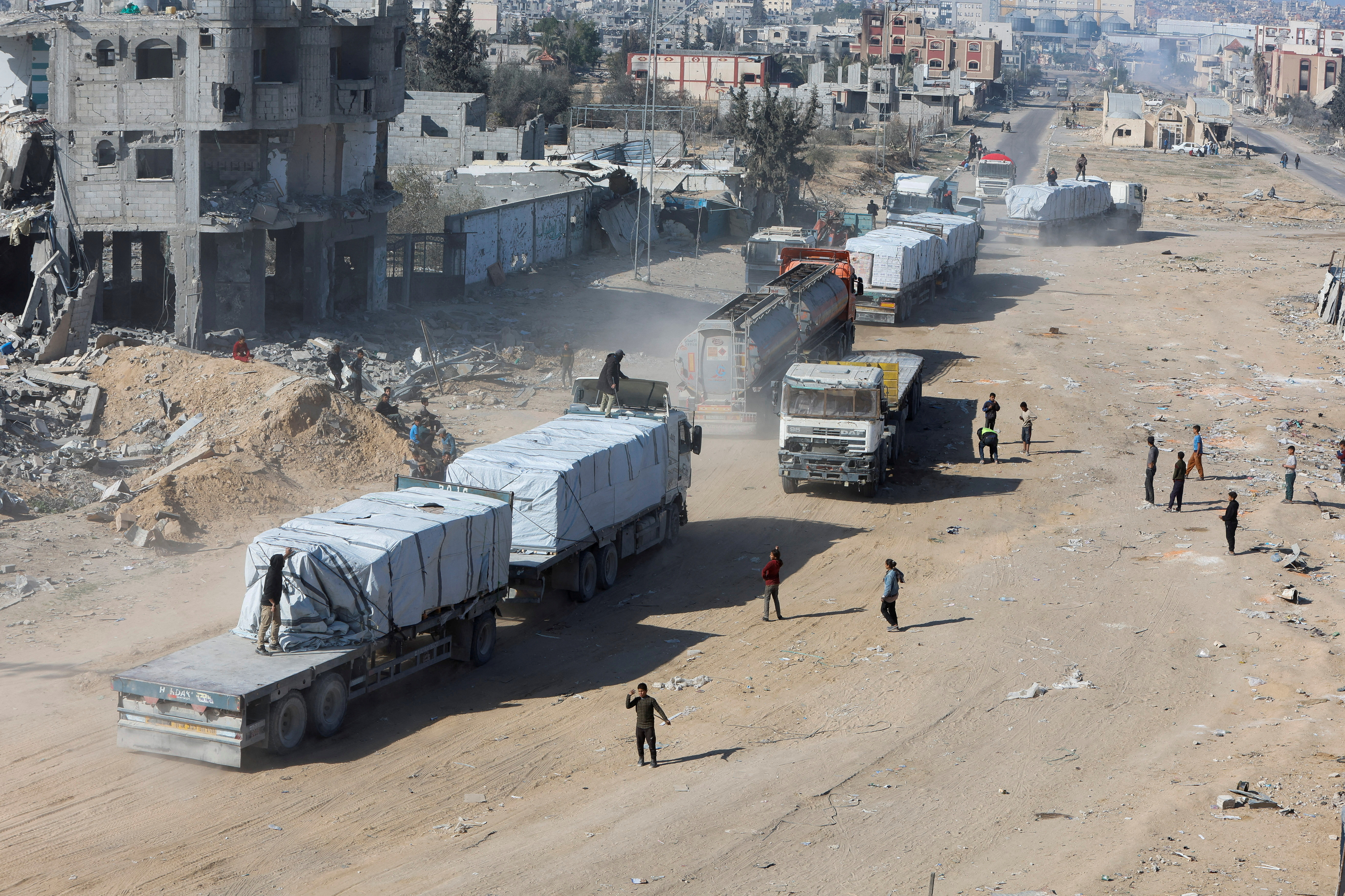 FILE PHOTO: Palestinians gather near trucks carrying aid, in Rafah