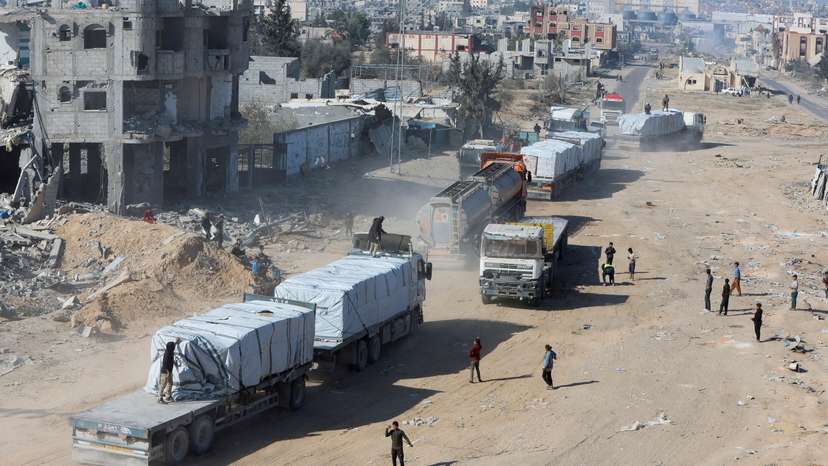 FILE PHOTO: Palestinians gather near trucks carrying aid, in Rafah