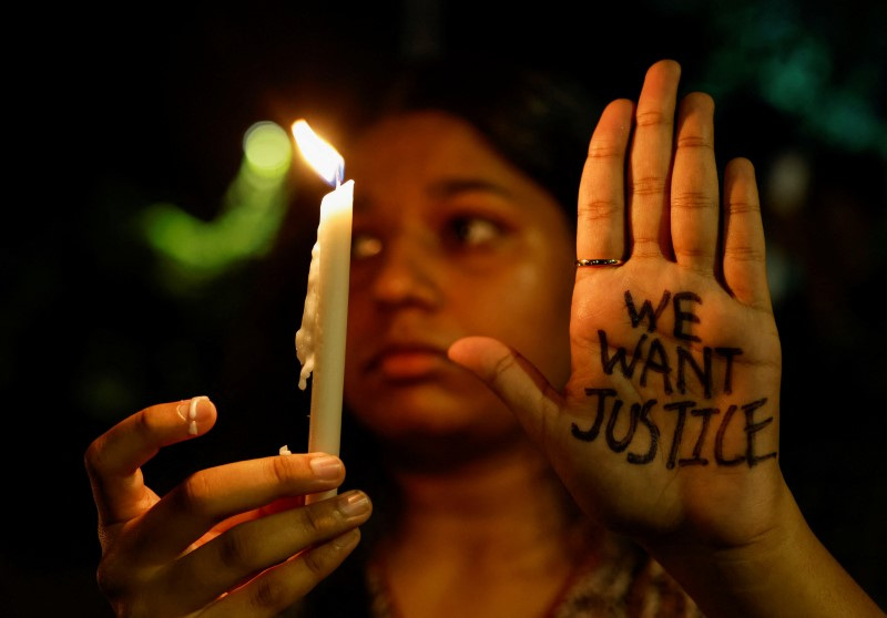 A woman holds a candle during a vigil condemning the rape and murder of a trainee medic at a government-run hospital in Kolkata, on a street in Mumbai