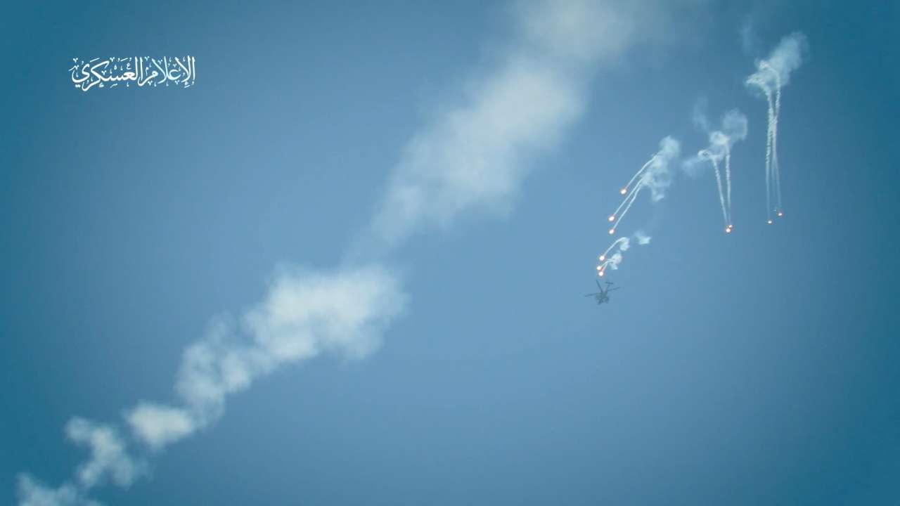 An Israeli military helicopter releases flares, amid the Israel-Hamas conflict, at a location given as Gaza