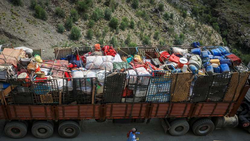 A man walks past a truck loaded with belongings of Afghan nationals, near Torkham border crossing