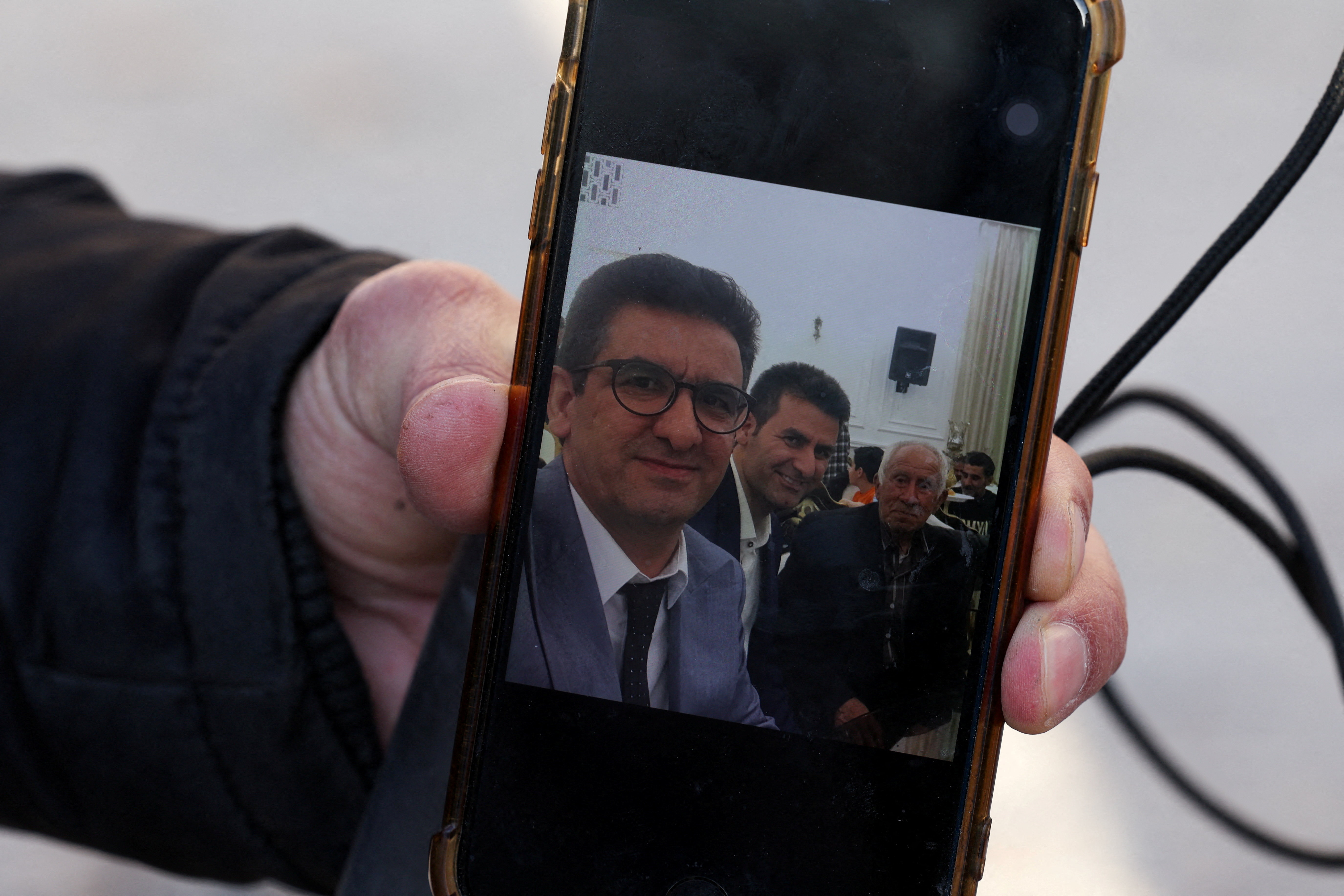 Hamid Mirzahosseini shows a picture of his missing brother, Mahdi Mirzahosseini, in Tehran