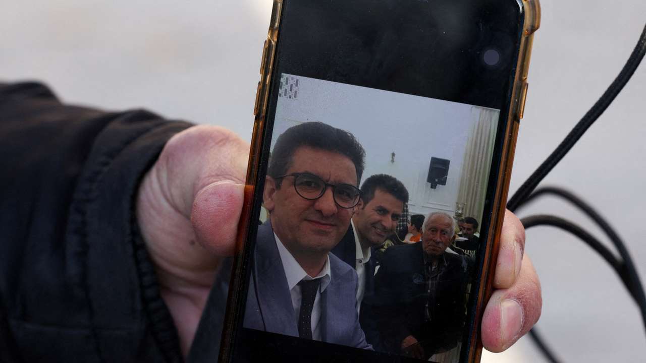 Hamid Mirzahosseini shows a picture of his missing brother, Mahdi Mirzahosseini, in Tehran