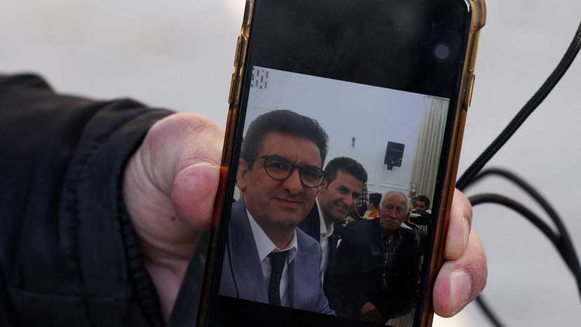 Hamid Mirzahosseini shows a picture of his missing brother, Mahdi Mirzahosseini, in Tehran