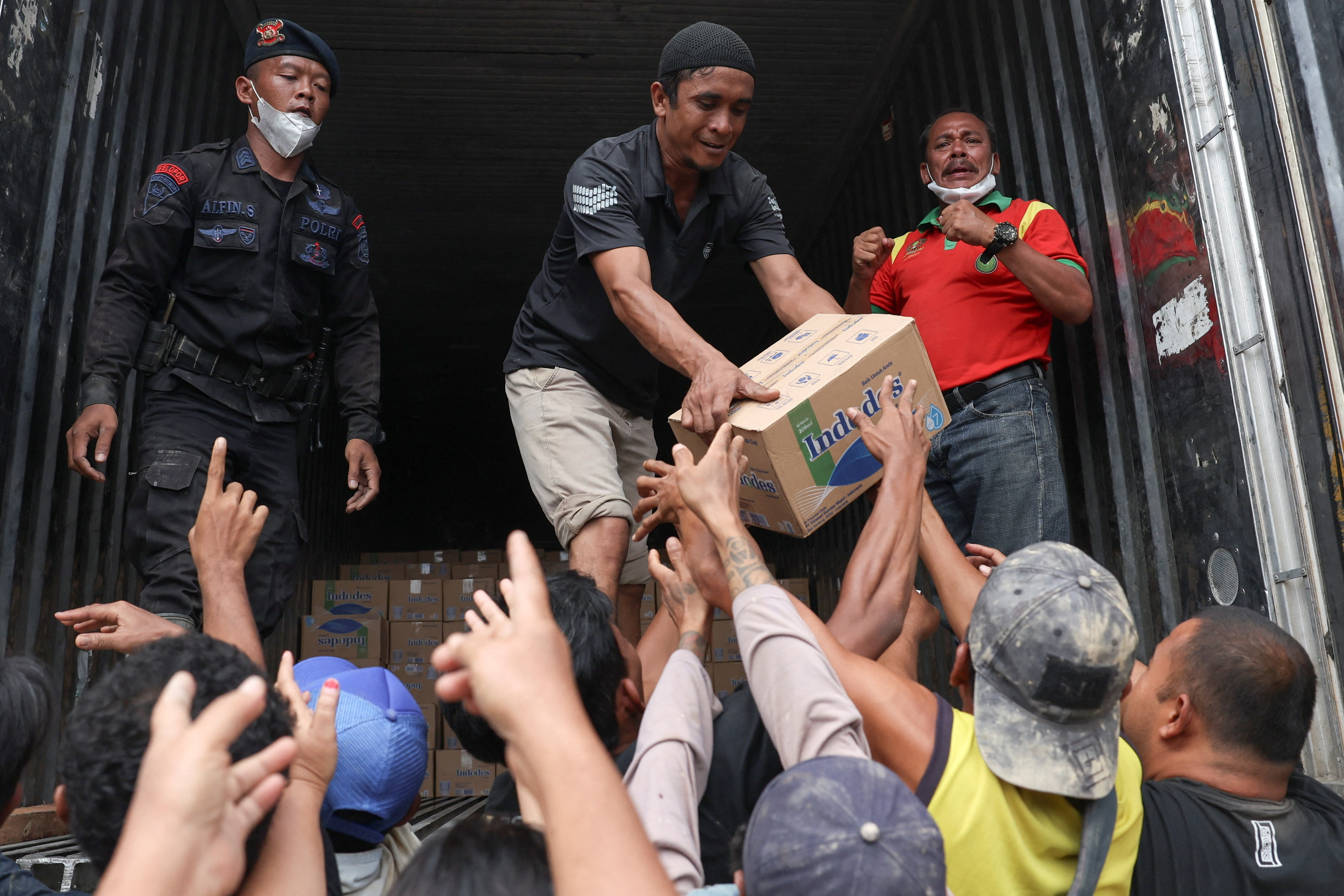Survivors collect relief supplies in an area affected by deadly flash floods following heavy rains in Kuala Simpang