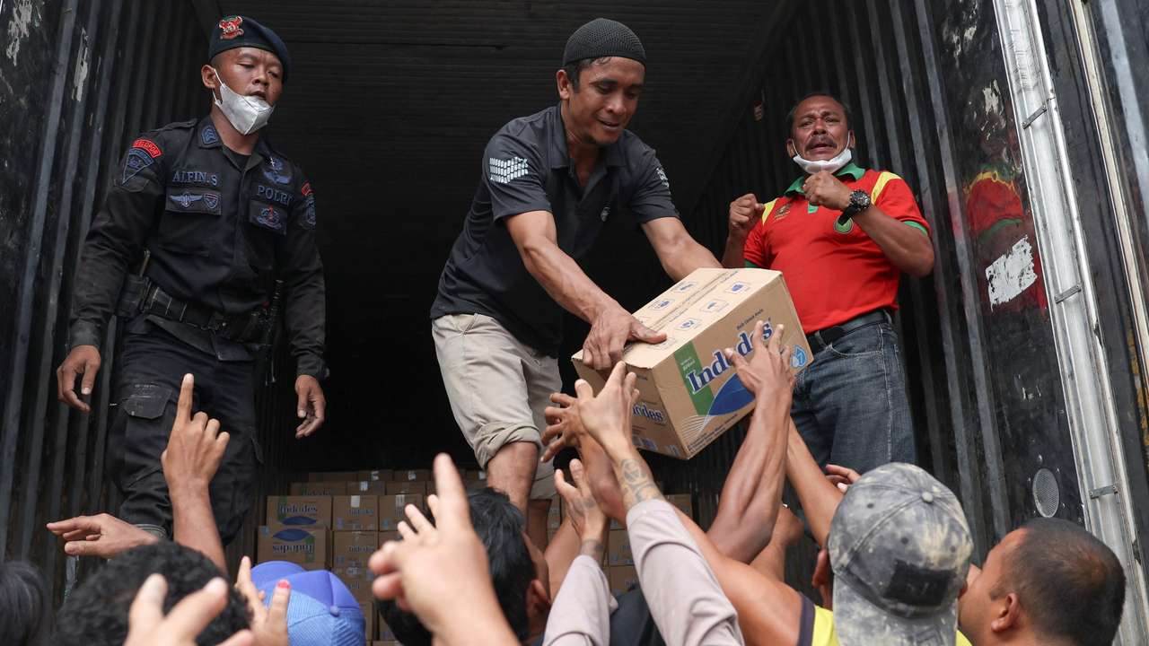 Survivors collect relief supplies in an area affected by deadly flash floods following heavy rains in Kuala Simpang