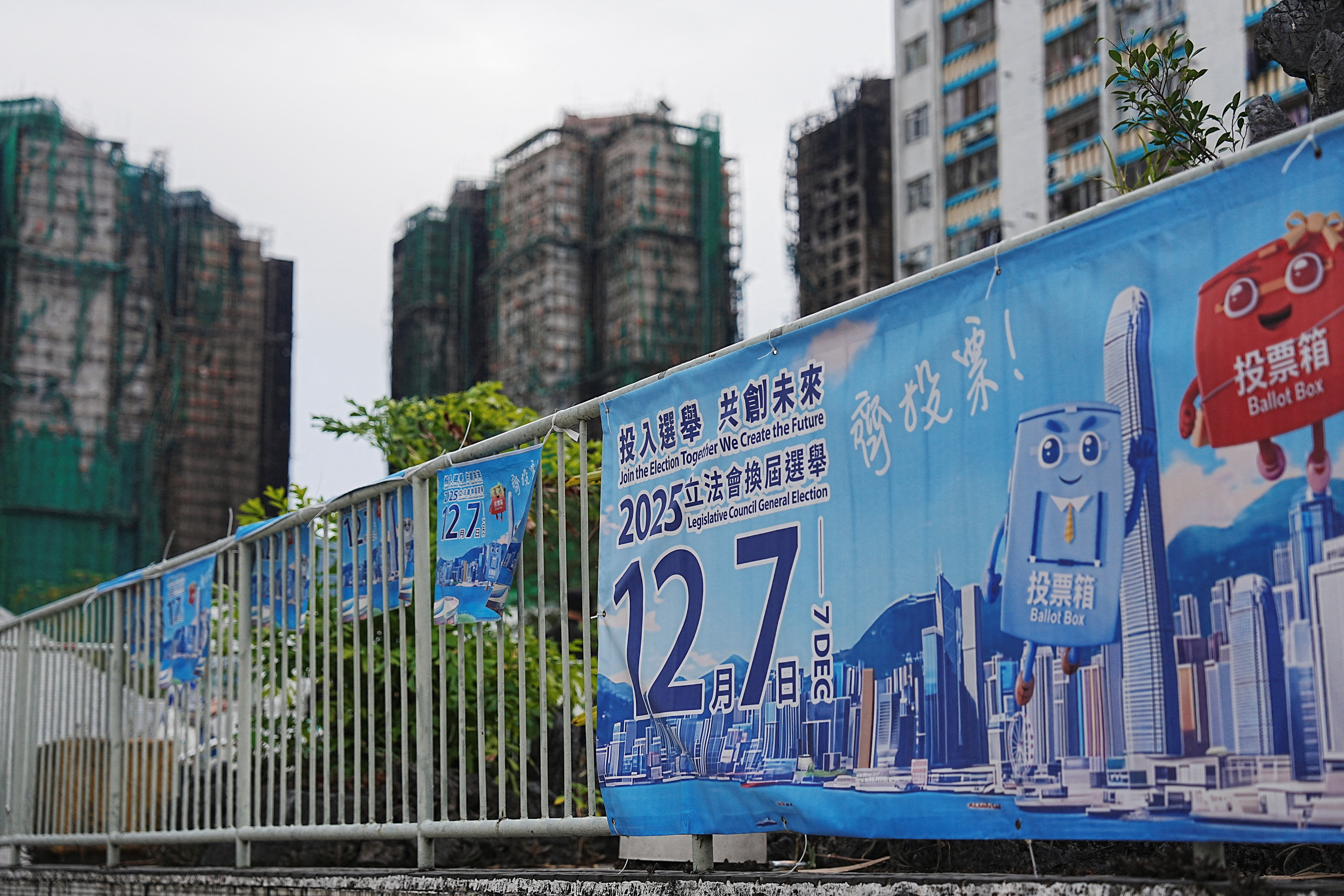 Posters for the upcoming legislative council election near the fire-damaged Wang Fuk Court housing complex in Tai Po, in Hong Kong