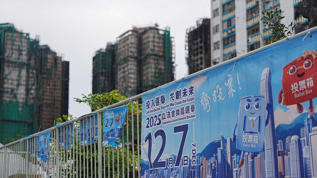 Posters for the upcoming legislative council election near the fire-damaged Wang Fuk Court housing complex in Tai Po, in Hong Kong