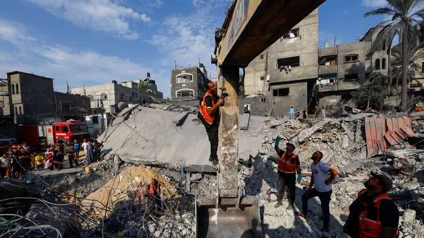 Emergency personnel work at the site of Israeli strikes on houses, in Khan Younis
