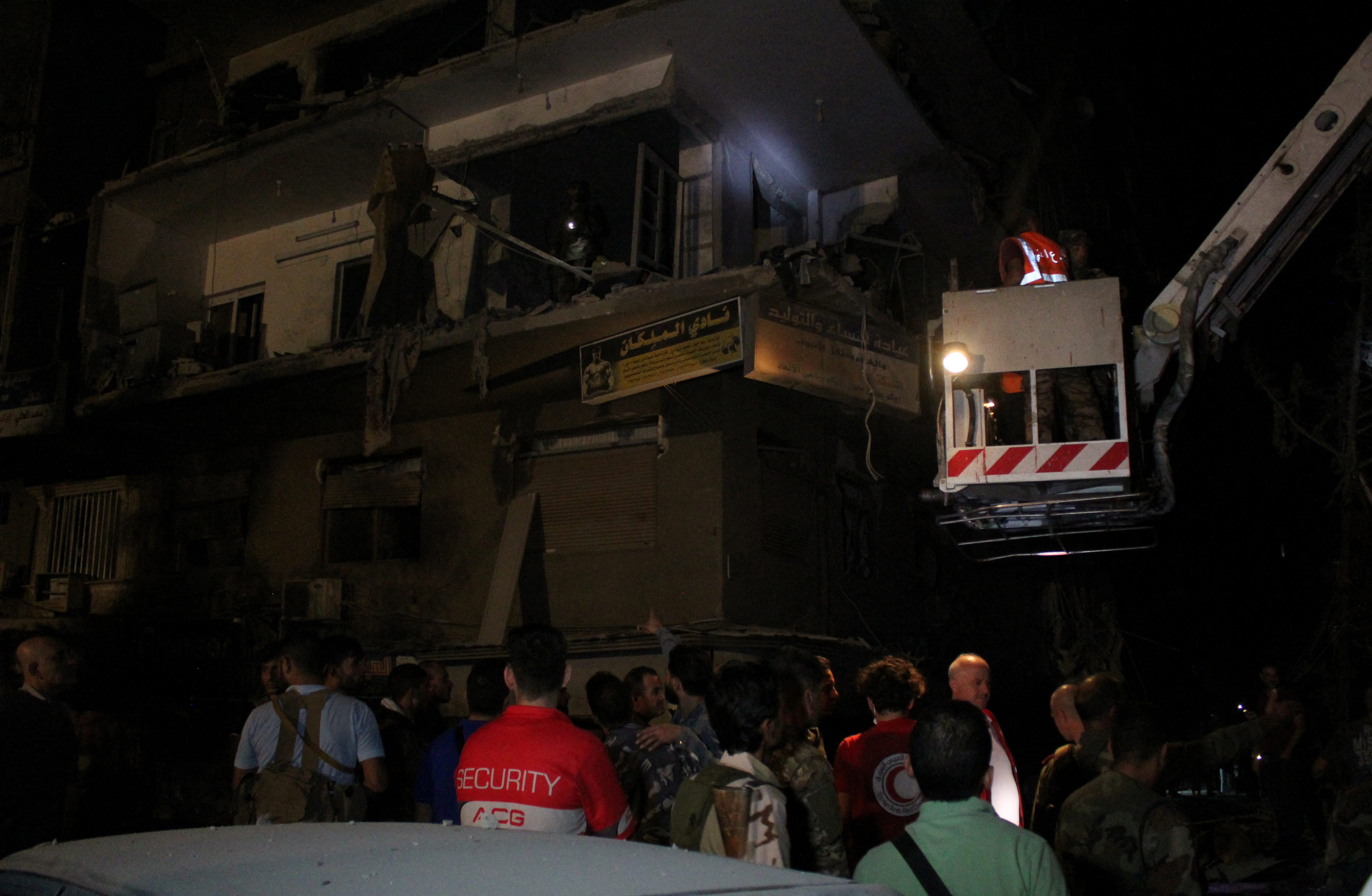 Rescuers work at the site of an Israeli airstrike that targeted a residential building in the Mezzah suburb in Damascus