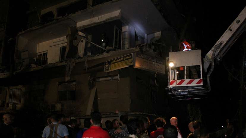 Rescuers work at the site of an Israeli airstrike that targeted a residential building in the Mezzah suburb in Damascus