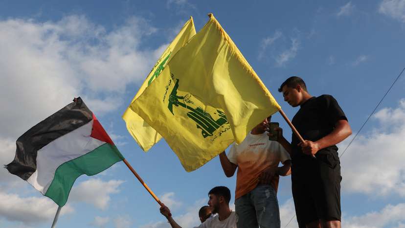 Demonstrators hold Hezbollah and Palestinian flags during in a protest condemning the killing of Hamas chief Ismail Haniyeh, in Sidon